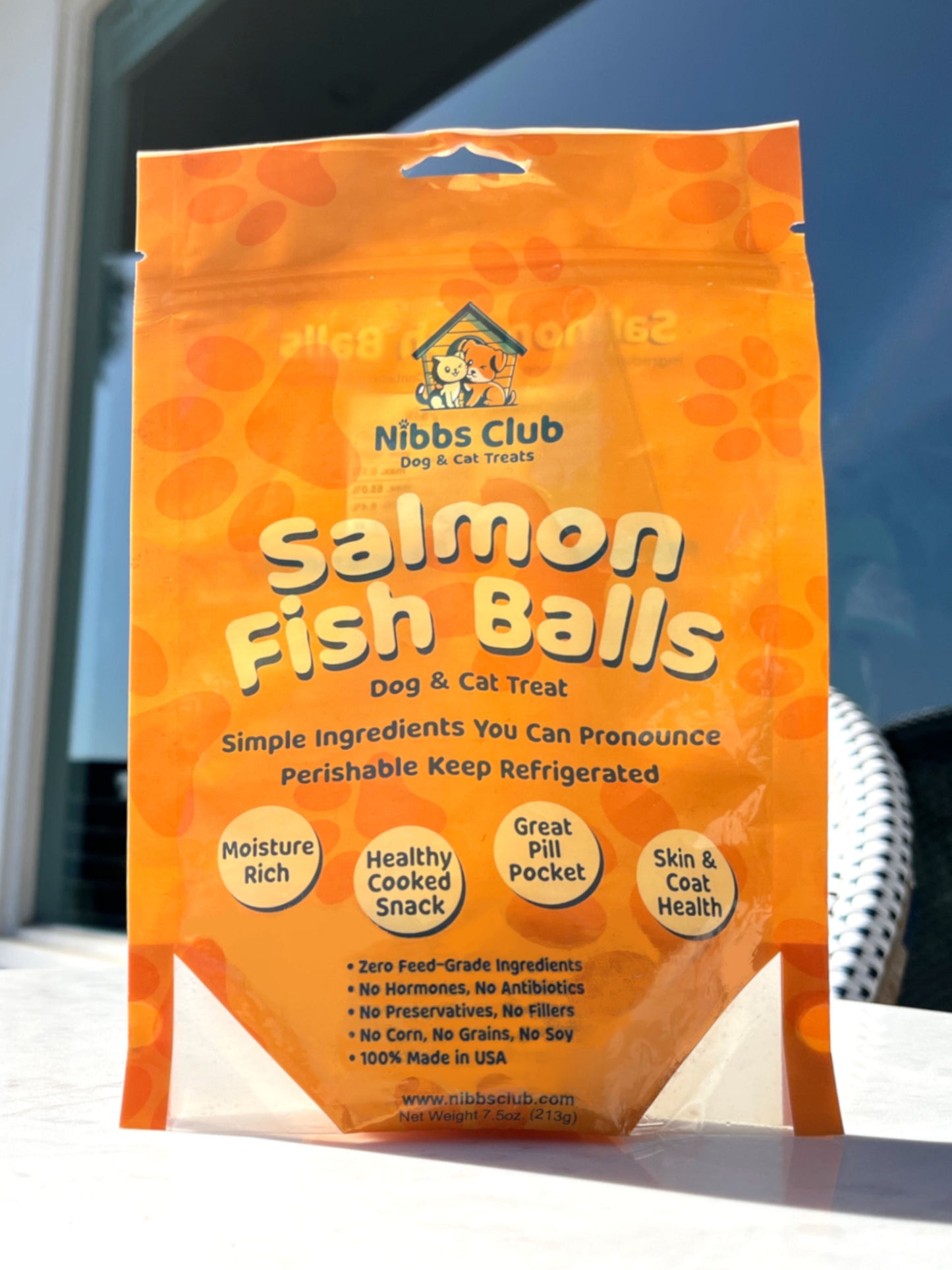 Salmon Fish Balls dog treat and cat treat pictured on a table outside